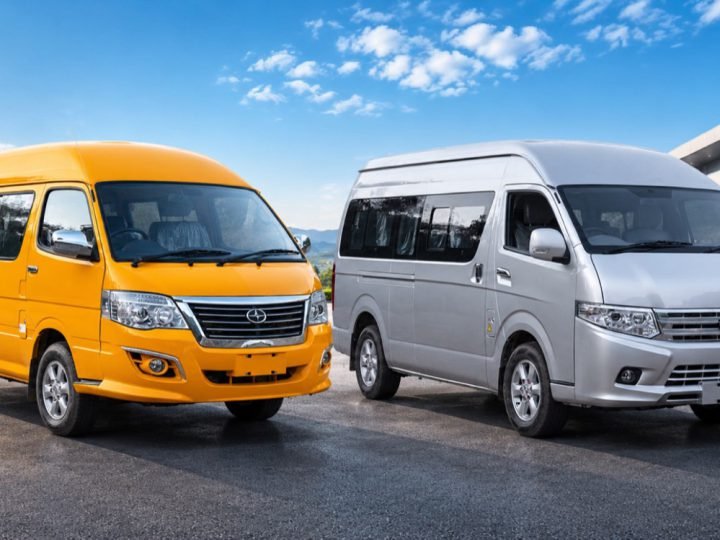 Yellow and silver electric mini-buses parked in front of a showroom